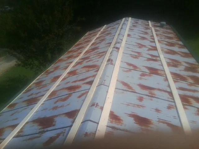 Rusted metal roof panels with new wood purlins before replacement — Storm Damage Roof Repair in Lawndale by Roofing Brothers