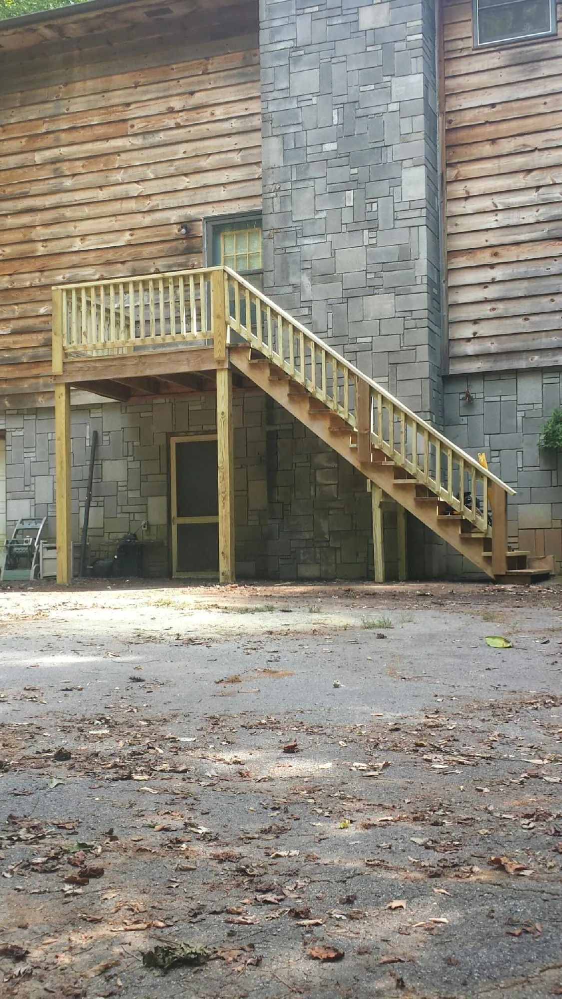 New pressure treated deck and stair landing on a log home in Lawndale